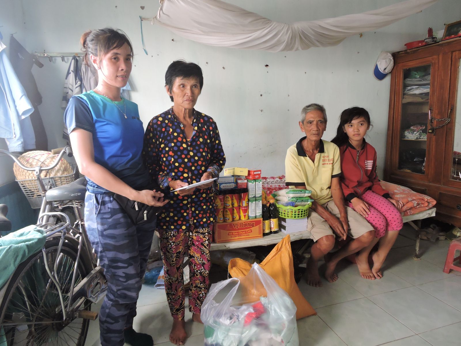 Đại diện nhóm từ thiện trao quà cho gia đình ông Phương