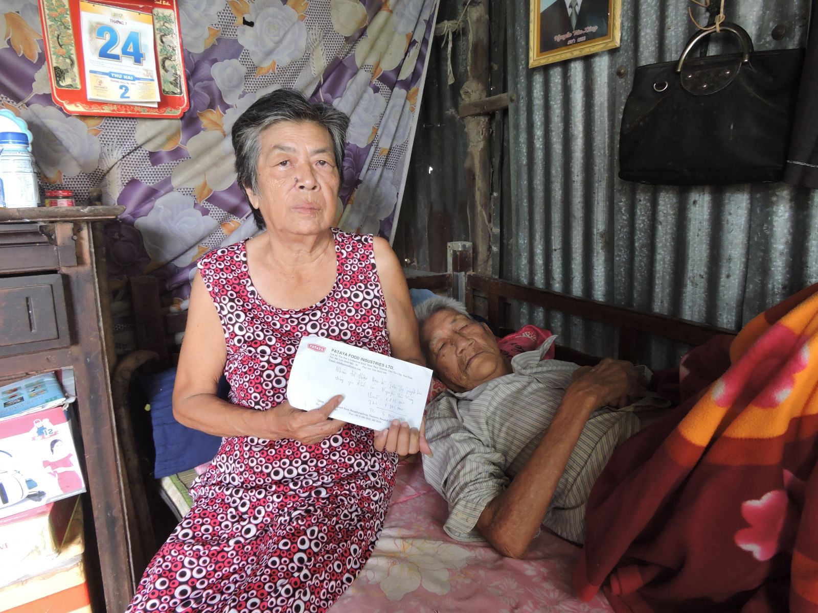 Vợ chồng ông Xứng nhận quà của nhóm từ thiện trao tặng