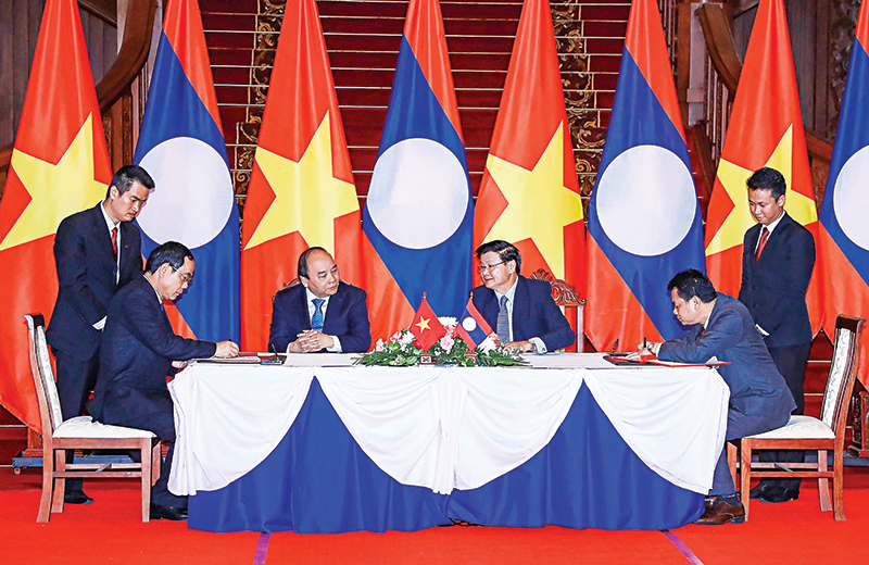Thủ tướng Nguyễn Xuân Phúc và Thủ tướng Lào Thongloun Sisoulith chứng kiến lễ ký Thỏa thuận hợp tác đầu tư giữa 2 nước. Ảnh: THỐNG NHẤT-TTXVN