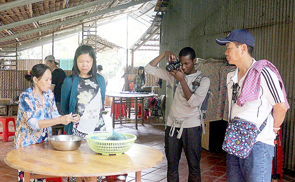 Du khách trải nghiệm làm bánh tại Cồn Sơn, Bình Thủy. Ảnh: ÁI LAM