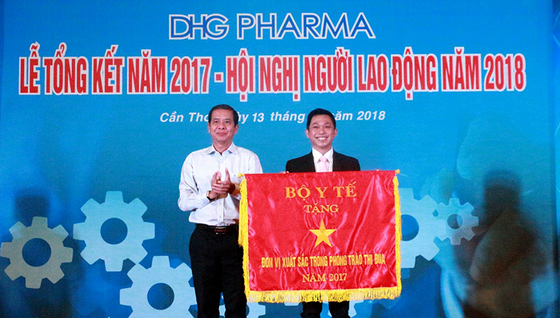 Phó Chủ tịch UBND TP Cần Thơ Nguyễn Thanh Dũng (bên trái) trao Cờ thi đua đơn vị xuất sắc trong phong trào thi đua năm 2017 của Bộ Y tế cho DHG Pharma. Ảnh: NAM HƯƠNG