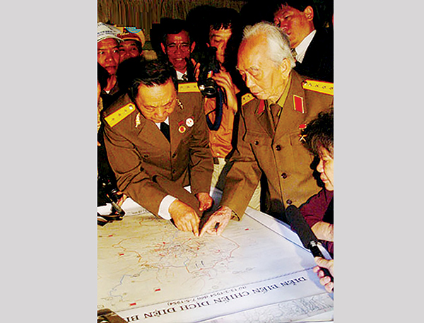 Tại Sở Chỉ huy Chiến dịch Điện Biên Phủ ở Mường Phăng, Thượng tướng Trần Văn Quang diễn tả lại với Đại tướng Võ Nguyên Giáp về công tác chỉ huy trận đánh “chấn động địa cầu”, khi hai lão tướng về thăm lại chiến trường xưa năm 2004. Ảnh: TL