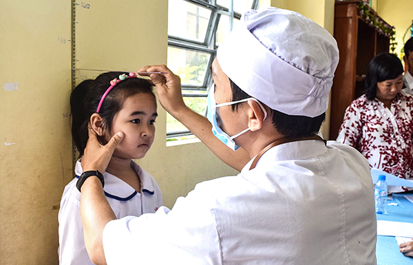 Cán bộ y tế Trạm Y tế phường Thới Hòa, quận Ô Môn, khám cho học sinh Trường Tiểu học Nguyễn Du theo nguyên lý y học gia đình.