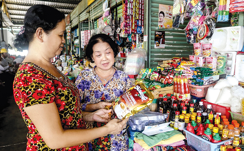 Tiểu thương chợ Cái Răng giới thiệu sản phẩm Việt cho khách hàng. Ảnh: MỸ HOA
