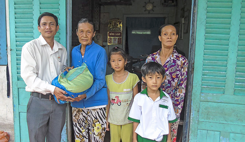 Cán bộ Hội Chữ thập đỏ phường Hưng Thạnh tặng gạo cho gia đình có trẻ mồ côi, hoàn cảnh khó khăn. Ảnh: NGUYỄN HUY
