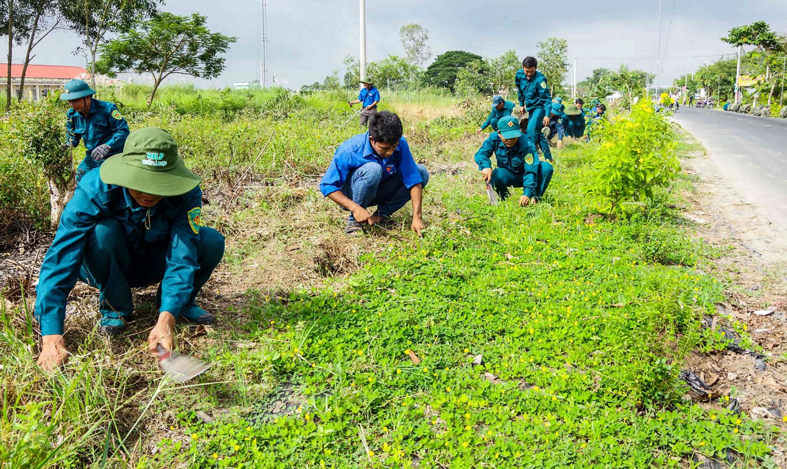 Dân quân huyện Cờ Đỏ tham gia vệ sinh môi trường, chăm sóc hoa. Ảnh: ĐỖ VĂN