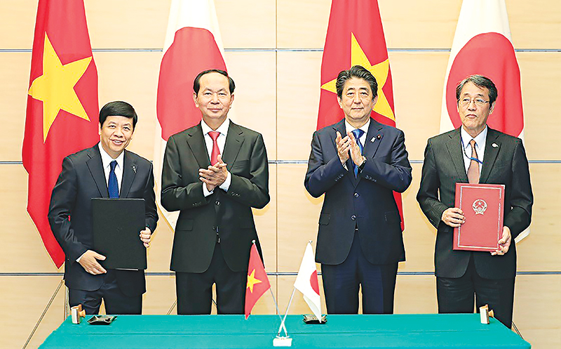Chủ tịch nước Trần Đại Quang và Thủ tướng Nhật Bản Shinzo Abe chứng kiến trao đổi Công hàm viện trợ không hoàn lại cho Dự án cải tạo, phục hồi đường ống thoát nước cũ xuống cấp bằng công nghệ không đào hở (SPR) tại thành phố Hồ Chí Minh. Ảnh: Nhan Sáng-TTXVN
