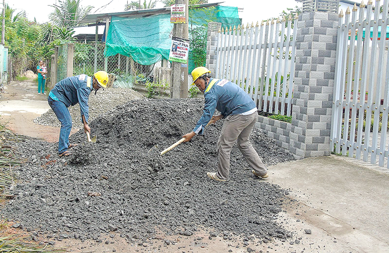 Sức mạnh từ lòng dân Các công nhân tiến hành xây dựng hẻm 4. Ảnh: THANH THY