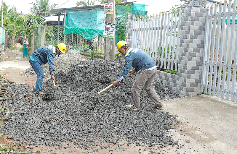 Các công nhân tiến hành xây dựng hẻm 4. Ảnh: THANH THY