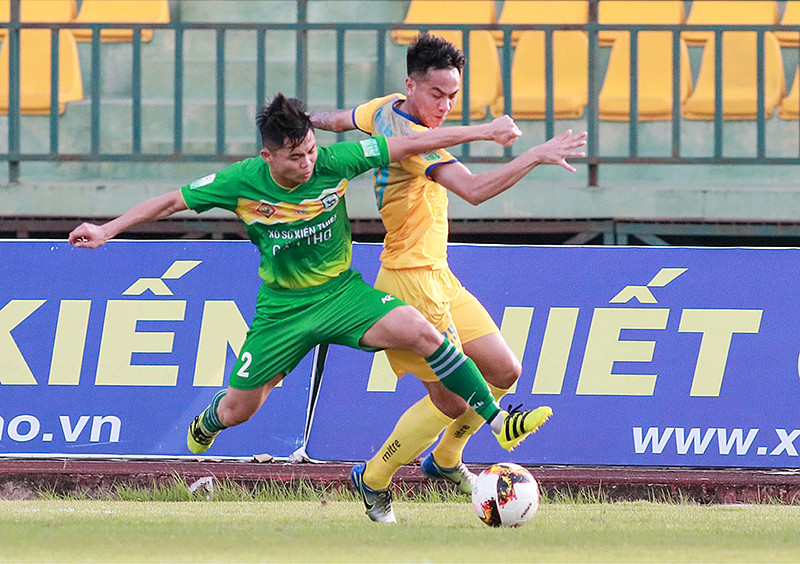 Hậu vệ Tùng Quốc (trái) của Cần Thơ tranh bóng với cầu thủ Thanh Hóa trong trận đấu vòng 14. Ảnh: Dương Thu