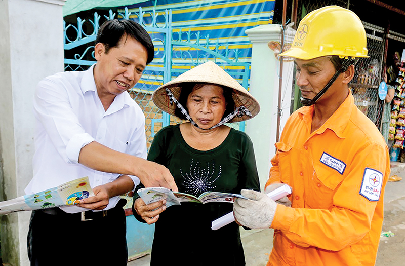 Cán bộ Công ty Điện lực TP Cần Thơ phát tờ rơi và  hướng dẫn sử dụng điện an toàn, tiết kiệm và hiệu quả cho người dân ở phường Ba Láng, quận Cái Răng. Ảnh: M.HOA