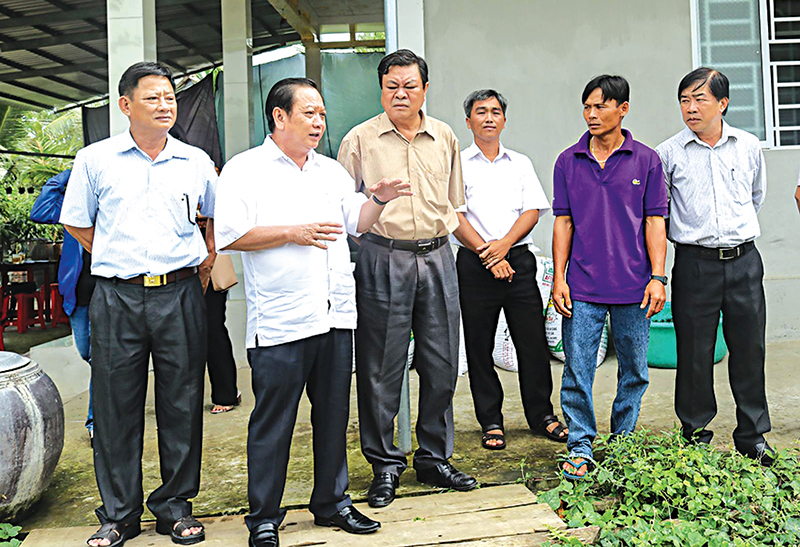 Bí thư Thành ủy Cần Thơ Trần Quốc Trung (thứ 2 từ trái sang) thăm mô hình nuôi ếch trong vèo của nông dân ở ấp Tân Lập, xã Thạnh Lộc, huyện Vĩnh Thạnh.