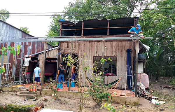 Người dân tại huyện Vĩnh Thạnh sửa chữa lại nhà cửa bị tốc mái do cơn lốc xoáy ngày 11-7-2018. Ảnh: HÀ VĂN