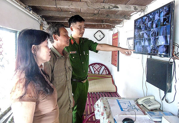 Cô Nguyễn Ngọc Báu cùng các cán bộ khu vực theo dõi hình ảnh hoạt động của các camera an ninh. Ảnh: THANH THY