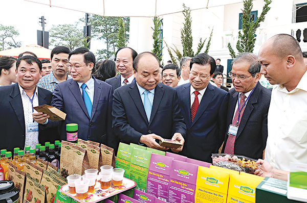 Thủ tướng Nguyễn Xuân Phúc, các Phó Thủ tướng: Vương Đình Huệ, Trịnh Đình Dũng thăm gian trưng bày một số sản phẩm nông sản chế biến tiêu biểu. Ảnh: VGP/QUANG HIẾU
