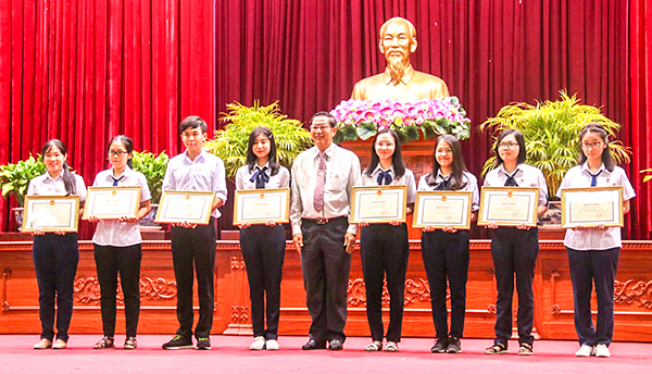Ông Lê Văn Tâm, Phó Chủ tịch Thường trực UBND thành phố, trao Bằng khen cho các học sinh giỏi. Ảnh: DUY KHÔI