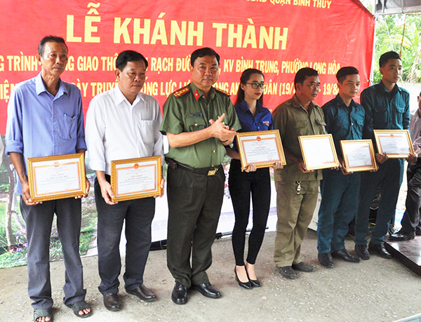 Đại tá Trần Ngọc Hạnh, Giám đốc Công an thành phố trao Giấy khen cho các cá nhân có thành tích tiêu biểu trong thực hiện công trình. Ảnh: ANH DŨNG