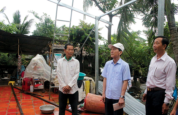 Chủ tịch UBND TP Cần Thơ Võ Thành Thống (giữa) đến thăm hỏi, động viên và hỗ trợ gia đình ông Trần Thanh Triều (xã Trường Long, huyện Phong Điền) bị sập nhà trong cơn lốc xoáy ngày 9-8. Ảnh: HÀ VĂN