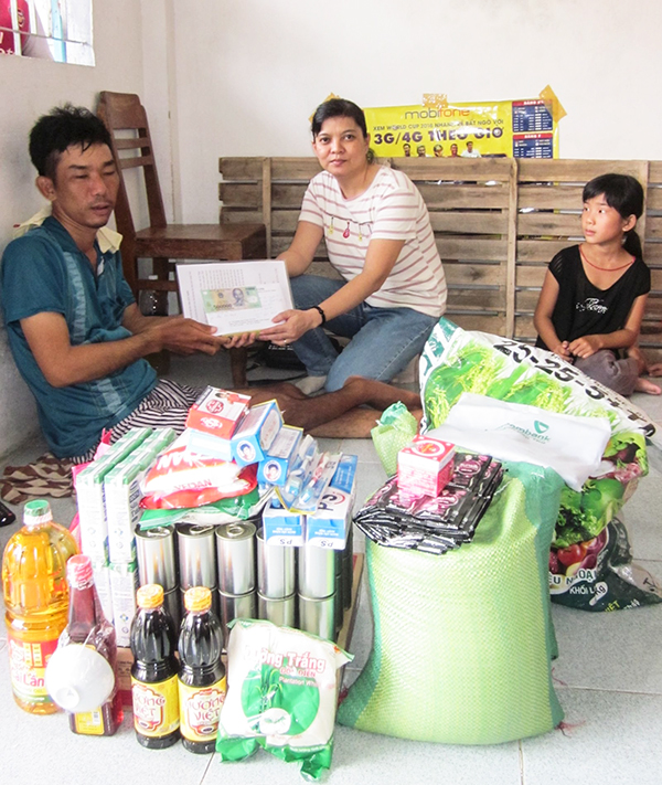Chị Tuyết Lan trao quà và động viên anh Nguyên cố gắng vượt khó, vui sống bên người thân.