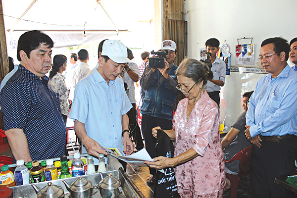 Chủ tịch UBND TP Cần Thơ Võ Thành Thống (thứ 2 từ phải sang) kiểm tra kiến thức phân loại rác của người dân tại quận Ninh Kiều. Ảnh: HÀ VĂN