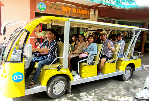 Hành khách rất thích thú tham quan TP Cần Thơ trên phương tiện xe 4 bánh chạy bằng năng lượng điện. Ảnh: XUÂN ĐÀO