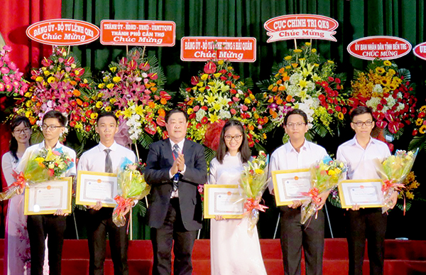 Giáo sư Hà Thanh Toàn (giữa) khen thưởng cho 5 tân sinh viên có điểm thi cao trong kỳ tuyển sinh đại học 2018. Ảnh: B.NGỌC