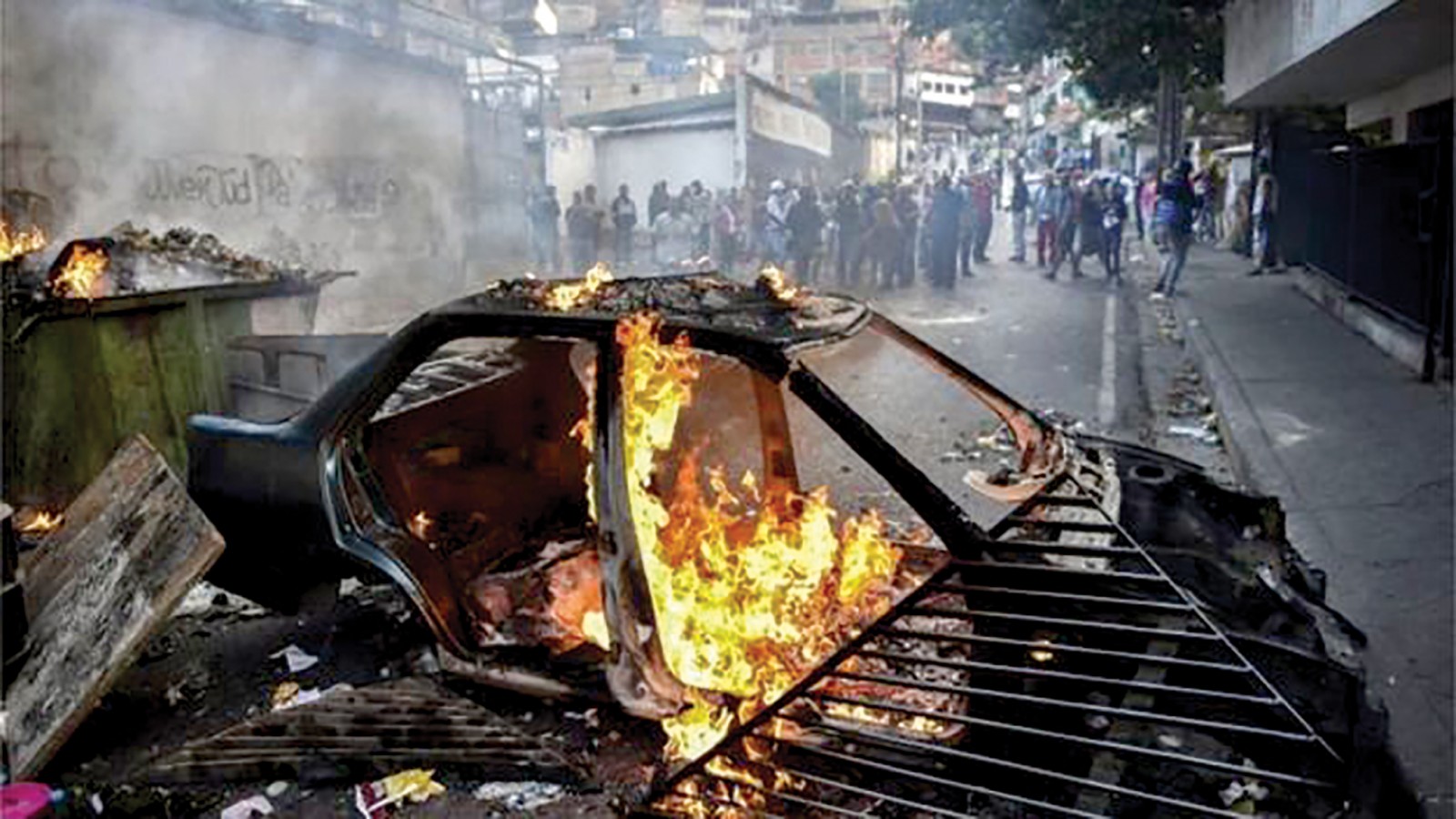 Một chiếc xe bị người biểu tình đốt trước trụ sở Vệ binh Quốc gia. Ảnh: AFP