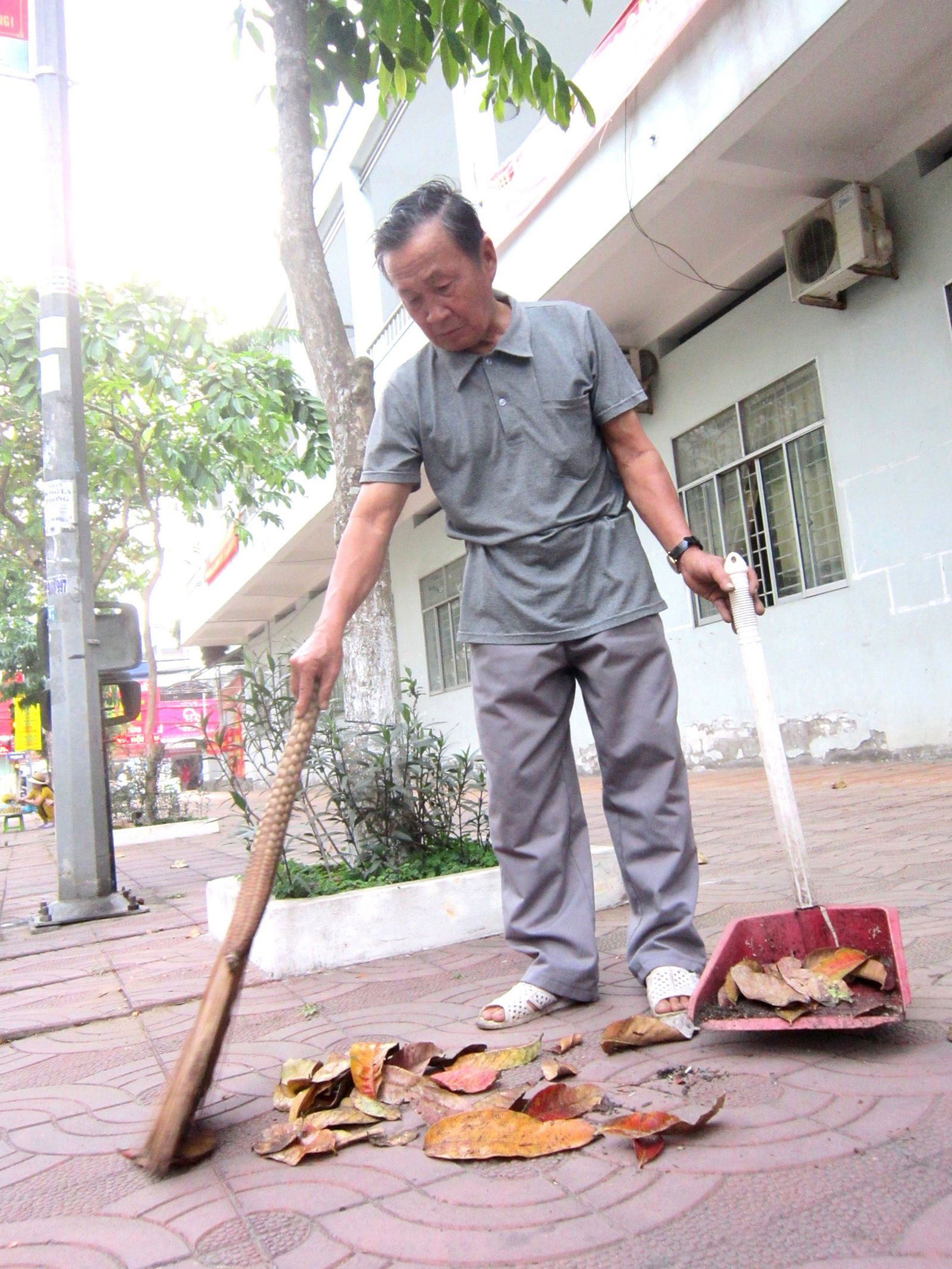 Ông Phạm Văn Hòa cần mẫn quét đường hơn 10 năm qua. Ảnh: CÁT ĐẰNG