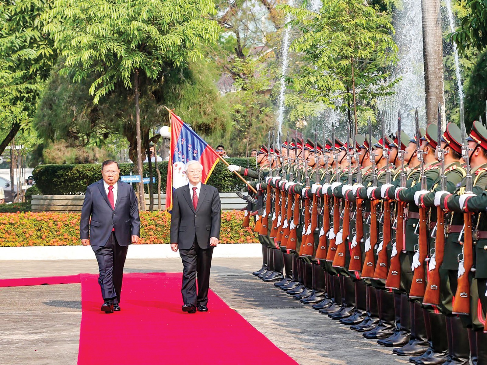 Tổng Bí thư, Chủ tịch nước Bounnhang Vorachith và Tổng Bí thư, Chủ tịch nước Nguyễn Phú Trọng duyệt đội danh dự Quân đội nhân dân Lào tại Lễ đón chính thức. Ảnh: TRÍ DŨNG – TTXVN