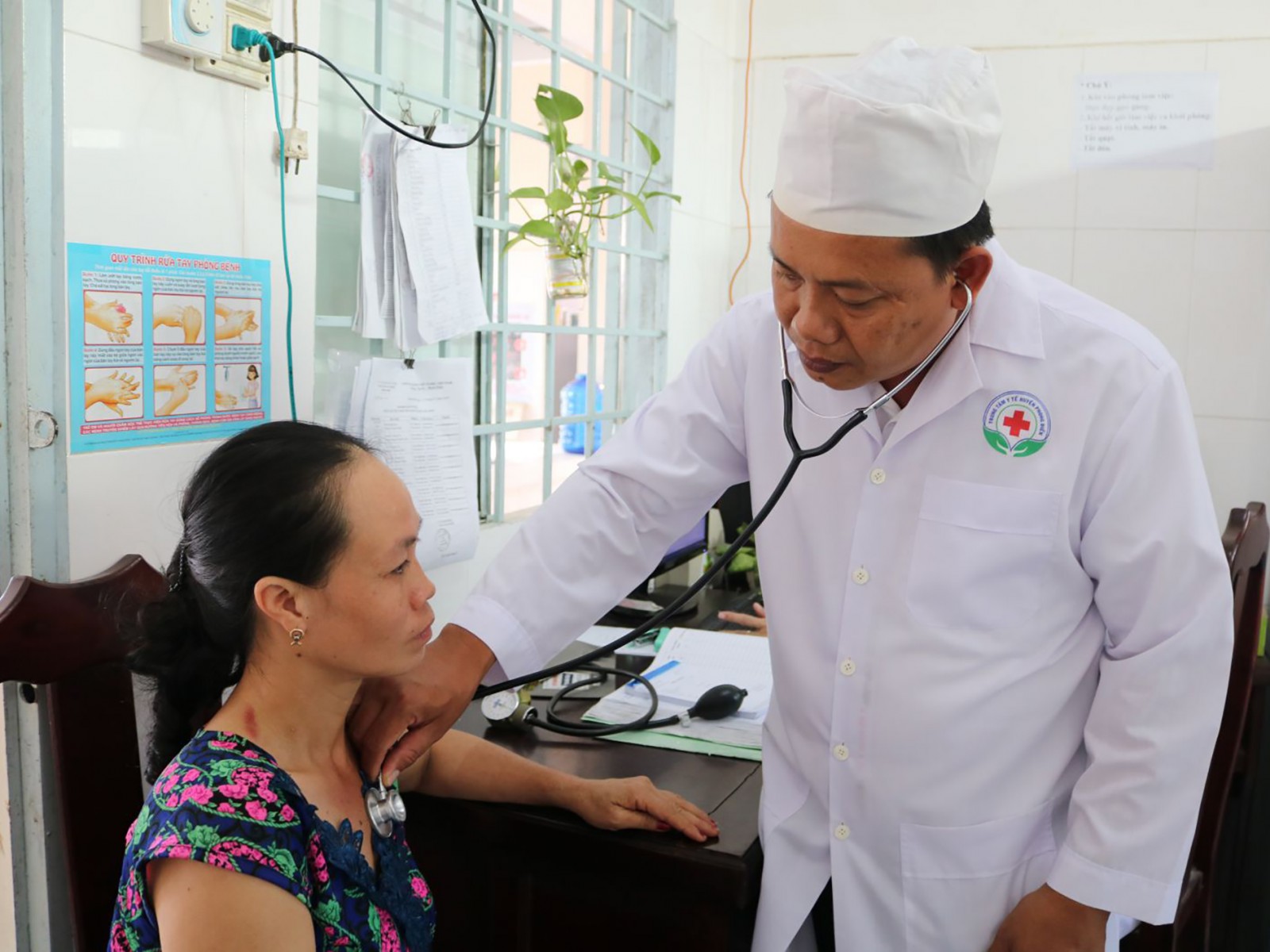 Bác sĩ Nguyễn Văn Sang khám bệnh cho người dân tại trạm y tế. Ảnh: H.HOA