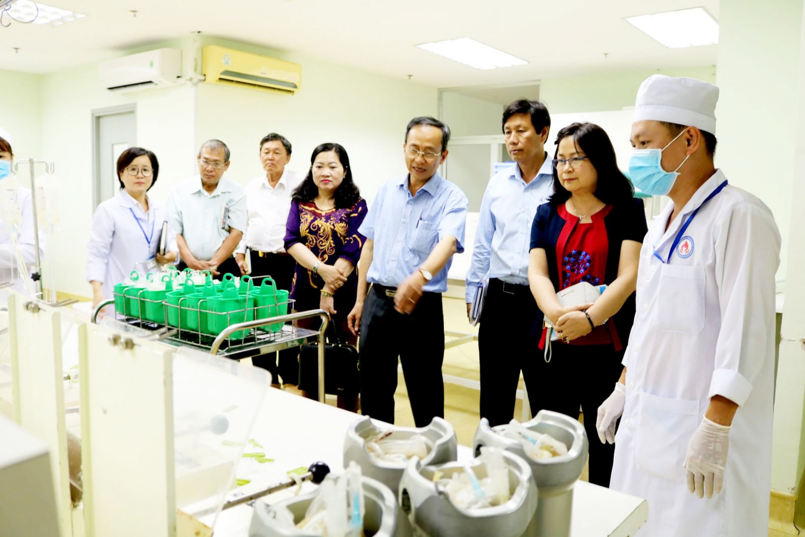 Bác sĩ Nguyễn Xuân Việt giới thiệu quy trình sàng lọc, sản xuất và lưu trữ máu tại BVHH- TMCT với Phó Chủ tịch UBND thành phố Võ Thị Hồng Ánh (thứ hai từ phải qua) và lãnh đạo các sở, ngành. Ảnh: H.HOA