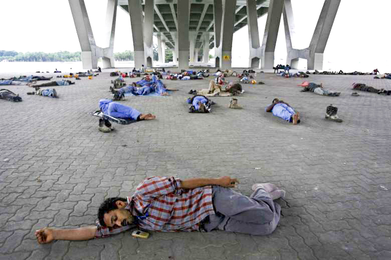Công nhân nhập cư tại Singapore tranh thủ nghỉ ngơi sau giờ ăn trưa. Ảnh: Straits Times