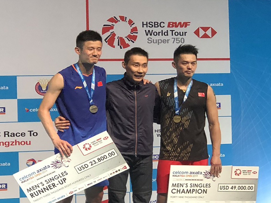 Lin Dan (phải) và Chen Long (trái) trên bục nhận thưởng Malaysia Open 2019. Ảnh: BWF