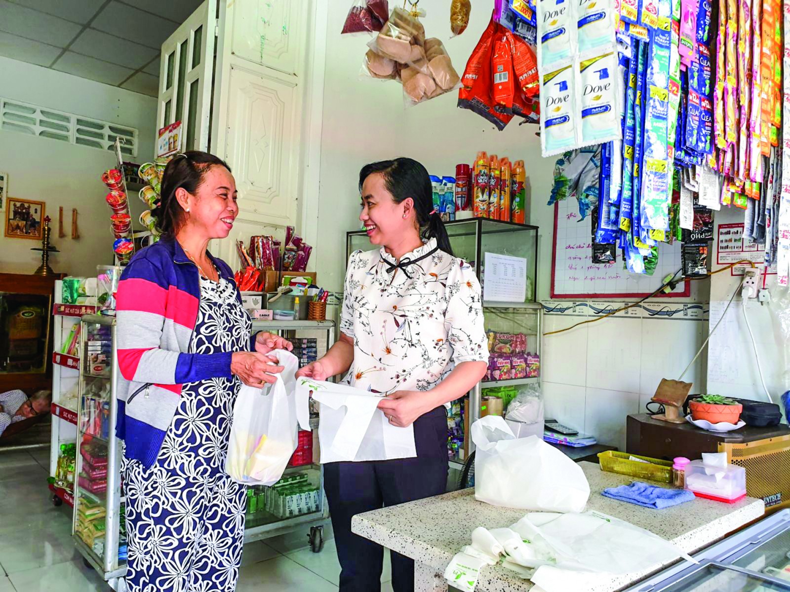 Sát cánh cùng hội viên Cán bộ Hội LHPN thị trấn Cờ Đỏ (bên phải) thường xuyên tuyên truyền, vận động chị em tiểu thương cam kết sử dụng túi sinh học trong mua bán thực phẩm.