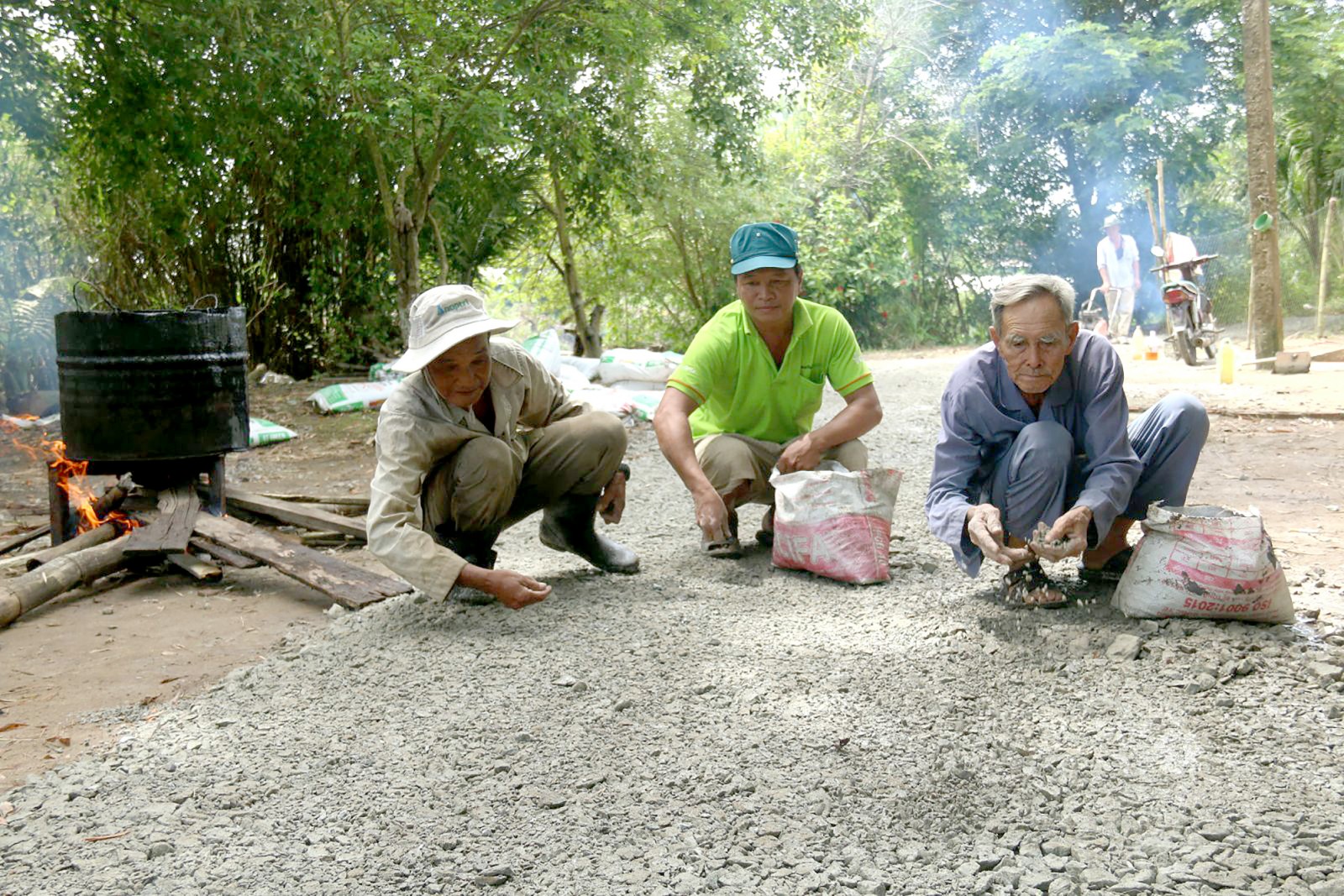 Bác Hai Phong (bìa phải) cần mẫn làm đường thiện nguyện ở tuổi 82.