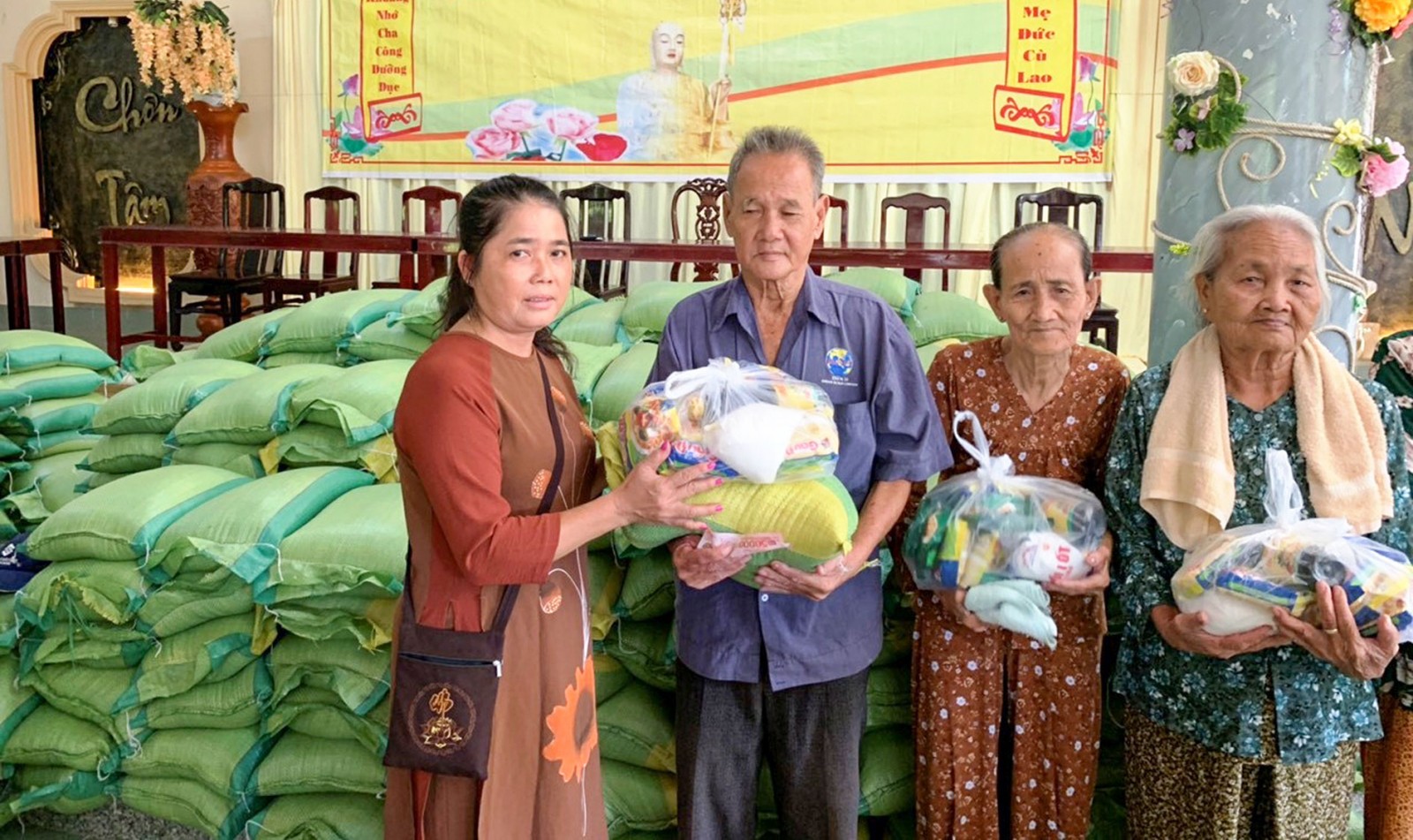 Chị Tuyết Sương (bìa trái) tặng gạo cho các hoàn cảnh khó khăn dịp Rằm tháng 7 vừa qua. Ảnh: Nhân vật cung cấp