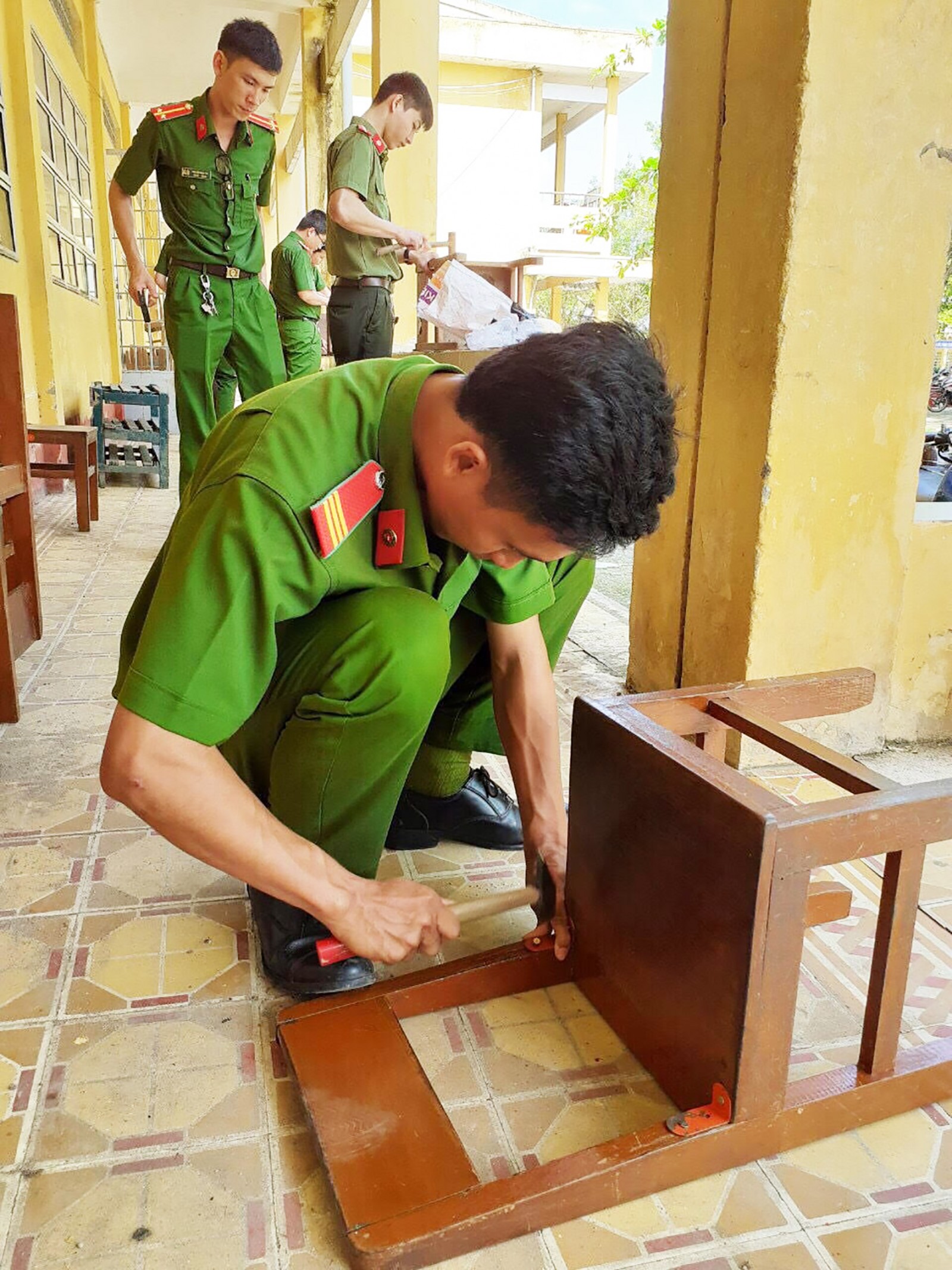 ĐVTN Công an quận tham gia sửa chữa bàn ghế ở Trường Tiểu học Thới Thuận 1.