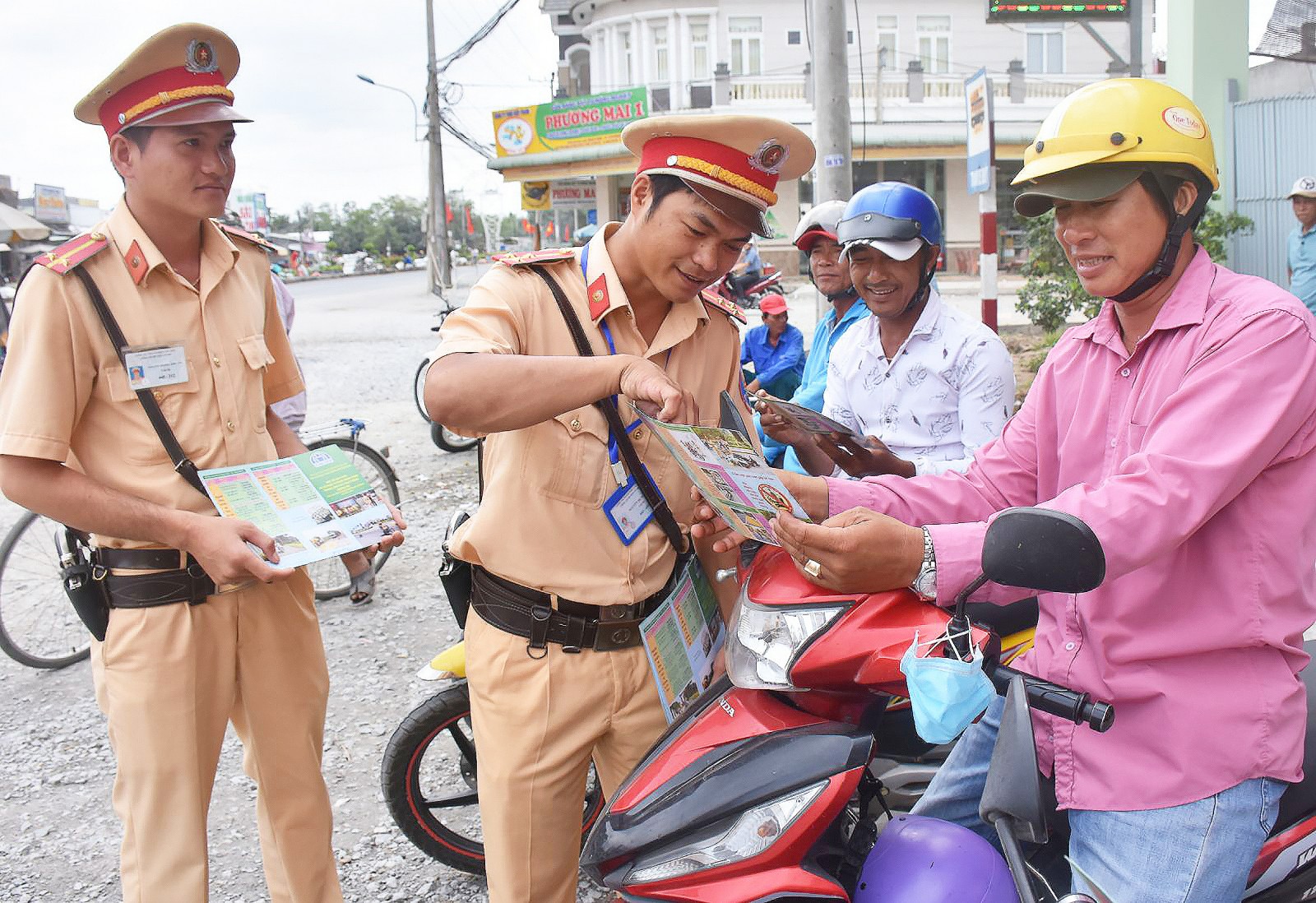 Cảnh sát giao thông Công an huyện Cờ Đỏ phát tờ rơi tuyên truyền cho các bác tài xe hon-da chở khách tại thị trấn Cờ Đỏ.
