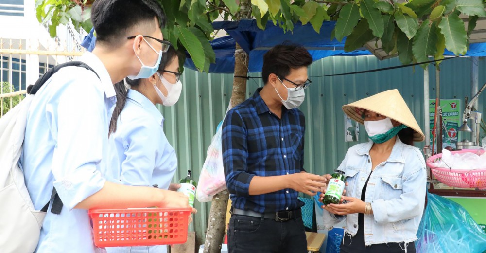 Sinh viên Trường Đại học Nam Cần Thơ tặng nước rửa tay sát khuẩn cho tiểu thương trên đường Nguyễn Văn Cừ, quận Ninh Kiều.