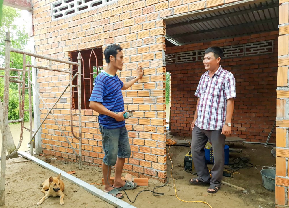 Cán bộ Ủy ban MTTQVN thị trấn Thới Lai thăm hỏi tình hình xây dựng nhà ở của các hộ nghèo.