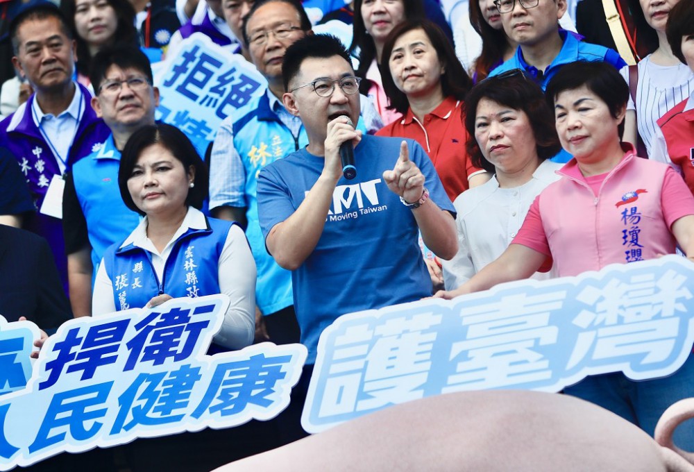 Chủ tịch KMT Giang Khải Thần (giữa) kêu gọi người dân phản đối nới lỏng lệnh cấm nhập thịt heo và bò từ Mỹ. Ảnh: CNA