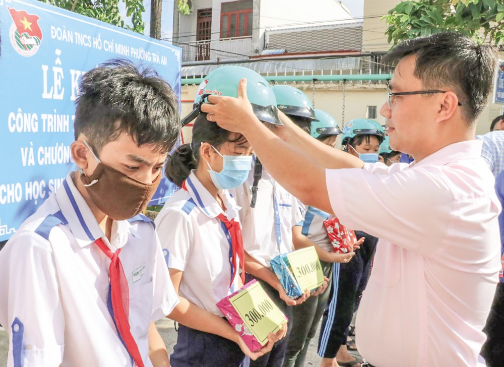 Ông Nguyễn Đức Tín, Phó Bí thư Thường trực Đảng ủy phường Trà An, quận Bình Thủy, trao học bổng, tập và nón bảo hiểm cho học sinh có hoàn cảnh khó khăn trước thềm năm học mới.