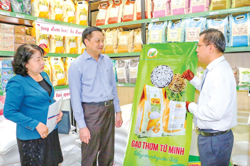 Trợ lực hàng Việt Ông Vũ Dương Quân, Giám đốc Trung tâm Điều hành Bán lẻ Satra Cần Thơ (bên phải), giới thiệu cho ông Dương Tấn Hiển, Phó Chủ tịch UBND TP Cần Thơ, về các sản phẩm gạo cao cấp sản xuất tại TP Cần Thơ đang bày bán tại Cửa hàng thực phẩm tiện lợi Satra Foods, đường Nguyễn Văn Cừ, quận Ninh Kiều.