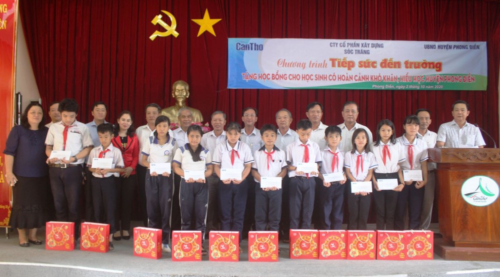 Đại diện Ban Biên tập Báo Cần Thơ, lãnh đạo huyện Phong Điền và nhà tài trợ trao học bổng cho các em học sinh.