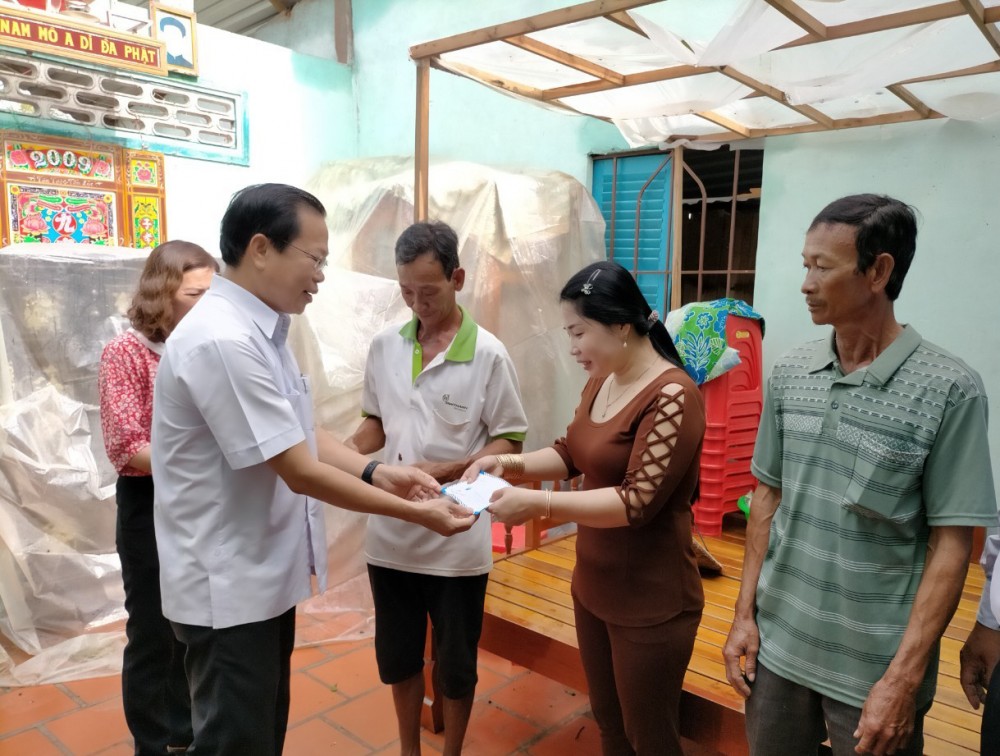 Ông Châu Việt Tha, Bí thư Huyện ủy Cờ Đỏ (bên trái) đến thăm hỏi và hỗ trợ chi phí sửa chữa nhà cửa cho gia đình bị tốc mái do mưa giông vào chiều 5-10. Ảnh: CTV