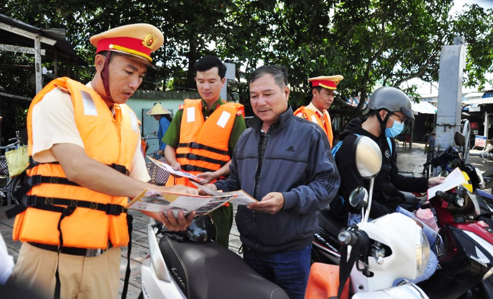 Lực lượng Trạm Cảnh sát đường thủy Thới An phát tờ rơi tuyên truyền cho hành khách bến đò Rạch Nọc, phường Phước Thới, quận Ô Môn.