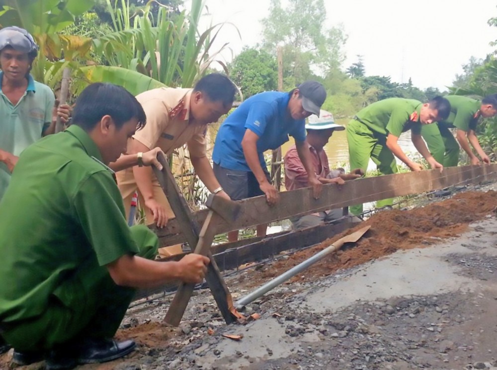 Cán bộ, chiến sĩ Chi đoàn CSGT-TT Công an quận Ô Môn và nhân dân tham gia nâng cấp, sửa chữa đoạn đường thuộc khu vực Bình Hòa.