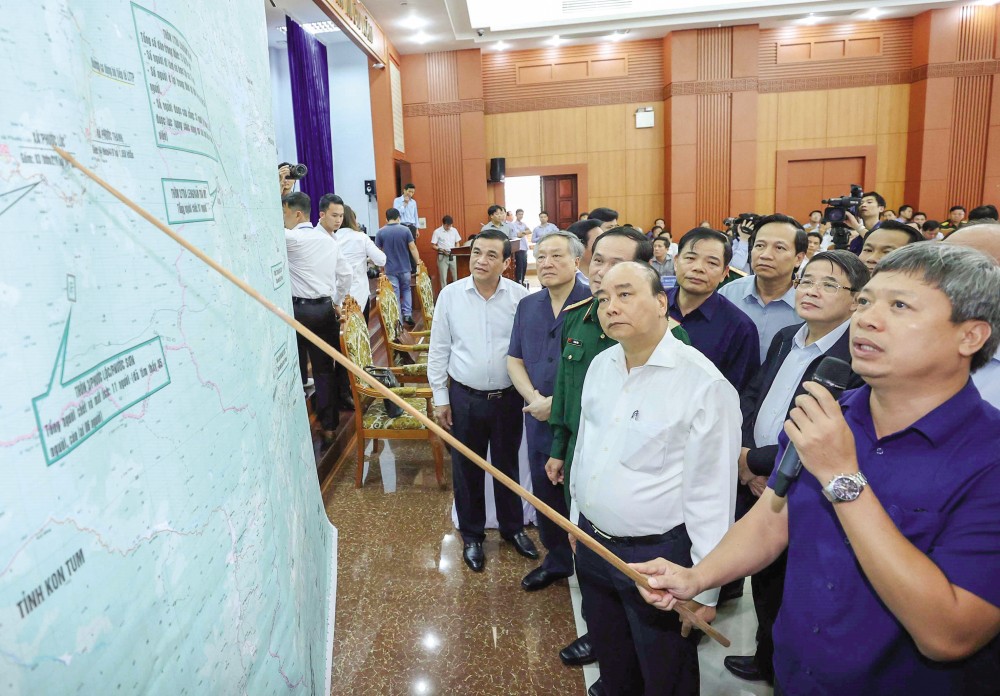 Thủ tướng Nguyễn Xuân Phúc và các đại biểu xem bản đồ chỉ huy cứu hộ, cứu nạn tại huyện Phước Sơn và Nam Trà My, Quảng Nam. Ảnh: THỐNG NHẤT - TTXVN