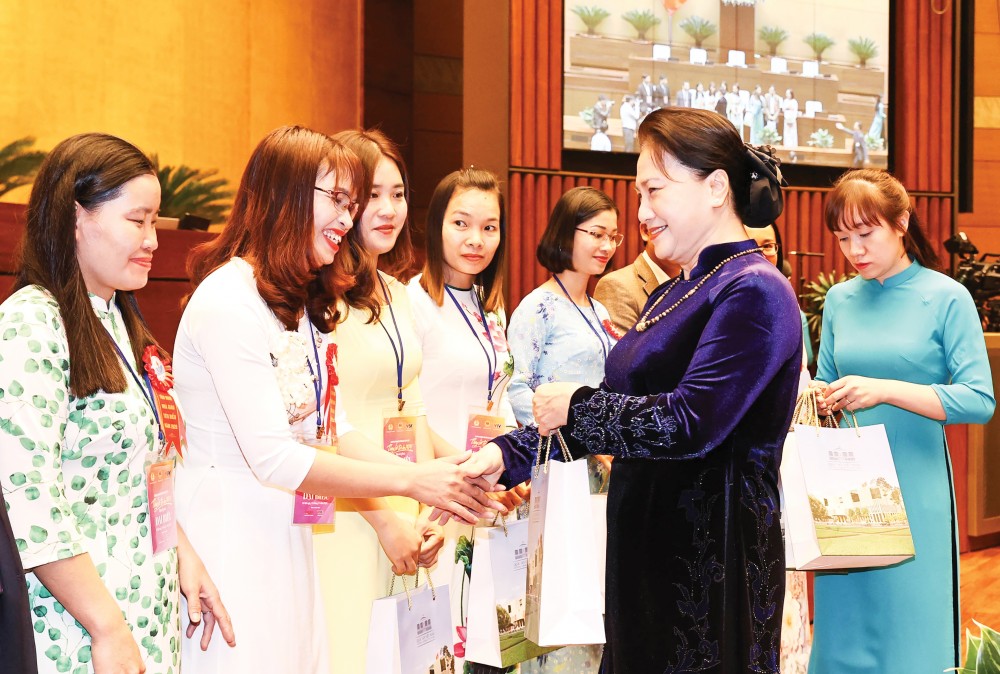 Chủ tịch Quốc hội Nguyễn Thị Kim Ngân tặng quà các giáo viên, nhà quản lý giáo dục tiêu biểu tại buổi gặp mặt. Ảnh: Trọng Đức - TTXVN