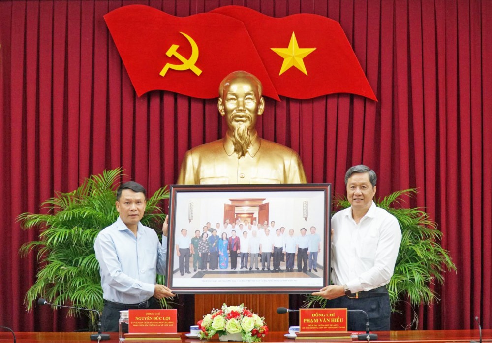 Đồng chí Phạm Văn Hiểu, Phó Bí thư Thường trực Thành ủy, Chủ tịch HĐND thành phố (bên phải) tặng quà lưu niệm cho TTXVN.